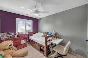 Bedroom with a ceiling fan and light colored carpet
