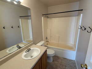 Bathroom featuring toilet, vanity, and washtub / shower combination