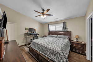 Bedroom featuring lofted ceiling, dark wood-style flooring, and ceiling fan