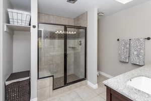 Full bath featuring a textured ceiling, vanity, tile patterned flooring, and a shower stall