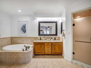 Primary ensuite bathroom featuring a double vanity, jetted bath tup and separate shower.