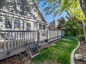 View of yard with a wooden deck and fence