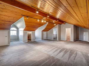 Bonus room with, vaulted ceiling, carpet flooring, and wood ceiling.