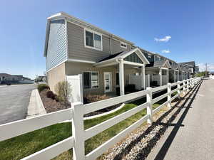 View of property exterior with privacy fence, covered patio, and a walking path