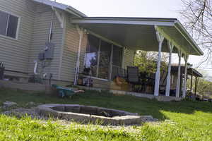 Rear view of property featuring a yard and a patio