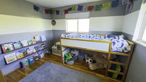 Bedroom featuring wood finished floors and multiple windows