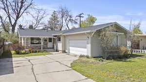 Ranch-style home featuring fence, a shingled roof, a front lawn, a garage, and driveway.