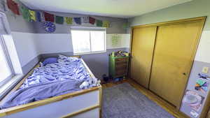 Bedroom with wood finished floors and a closet