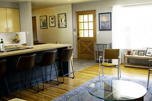 Kitchen featuring tasteful backsplash, wood finished floors, and a bar area
