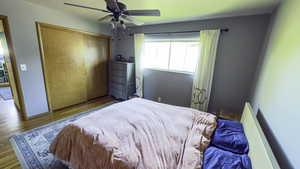 Bedroom featuring ceiling fan, wood finished floors, and a closet