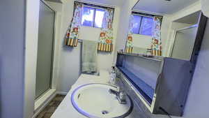 Full bathroom with a shower stall, baseboards, and vanity