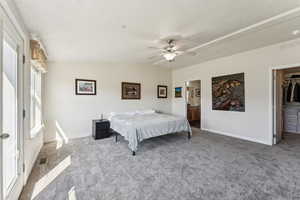 Carpeted bedroom featuring lofted ceiling, baseboards, visible vents, and a spacious closet