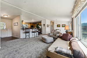 Living area featuring baseboards, carpet flooring, a textured ceiling, and a notable chandelier