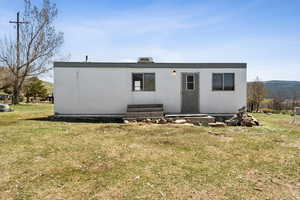 View of front of property featuring entry steps, a front yard, and fence