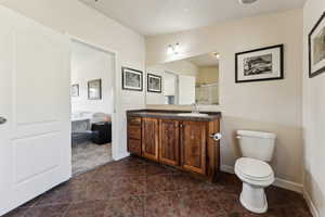Full bath with baseboards, toilet, vanity, and a stall shower