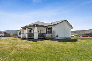 Exterior space featuring fence, a lawn, covered porch, and a mountain view