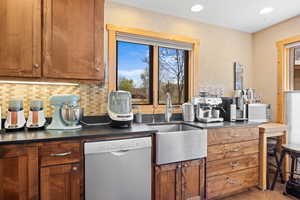 Kitchen featuring brown cabinets, dishwasher, and plenty of natural light
