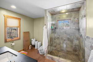 Full bath with a shower stall, a sink, baseboards, toilet, and recessed lighting