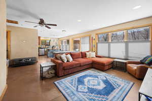 Living area featuring recessed lighting, ceiling fan, concrete floors, and plenty of natural light