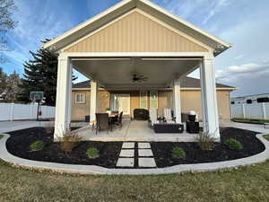 View of patio with a ceiling fan and fence
