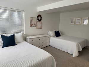 Bedroom with carpet, a textured ceiling, and multiple windows