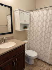 Full bath with a shower with curtain, vanity, and toilet