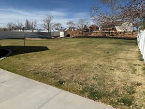 View of yard with fence and volleyball court