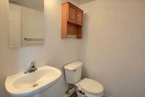 Bathroom with baseboards, a sink, and toilet