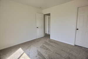Unfurnished bedroom featuring carpet floors and baseboards
