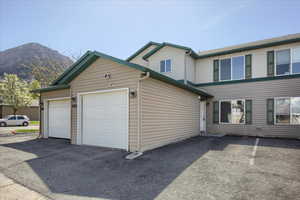 View of side of home with a mountain view and a garage