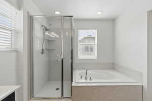 Full bathroom with a garden tub, vanity, and a shower stall