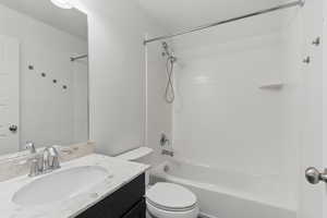 Bathroom with toilet, vanity, and washtub / shower combination