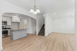 Kitchen with recessed lighting, light wood-type flooring, appliances with stainless steel finishes, and open floor plan