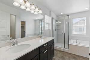 Bathroom with a garden tub, a sink, a shower stall, and double vanity