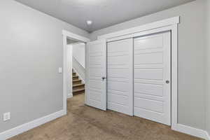 Unfurnished bedroom with baseboards, carpet floors, and a closet