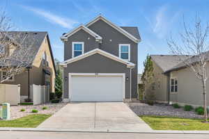 Traditional-style home with fence, concrete driveway, and stucco siding