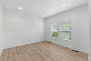 Unfurnished room with light wood finished floors, baseboards, visible vents, and recessed lighting