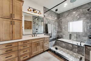 Full bathroom with tile patterned flooring, a tub with marble appearance, a shower with shower door, and vanity