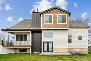 Back of property featuring a yard, board and batten siding, and french doors