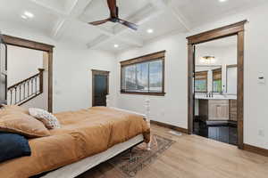 Bedroom featuring coffered ceiling, wood finished floors, visible vents, beam ceiling, and baseboards