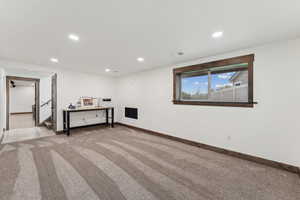 Basement with baseboards, carpet flooring, stairs, and recessed lighting