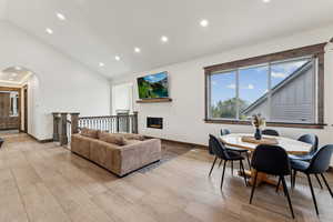 Living area featuring arched walkways, lofted ceiling, recessed lighting, and baseboards