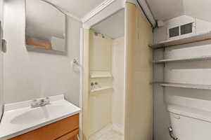 Bathroom with vanity, a shower, and toilet