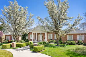 Neoclassical / greek revival house with brick siding and a front yard
