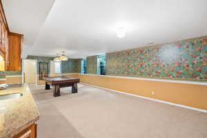 Game room with a sink, wallpapered walls, pool table, light colored carpet, and baseboards