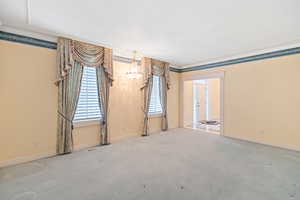 Spare room with baseboards, a notable chandelier, carpet flooring, and visible vents