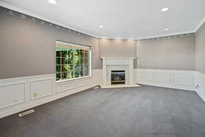 Unfurnished living room featuring recessed lighting, a high end fireplace, visible vents, and carpet flooring