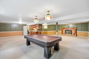Rec room featuring wallpapered walls, a wainscoted wall, pool table, and light colored carpet