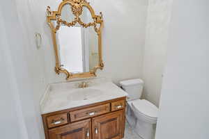 Bathroom featuring marble finish floor, toilet, and vanity