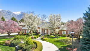 Neoclassical home featuring a front yard and a mountain view